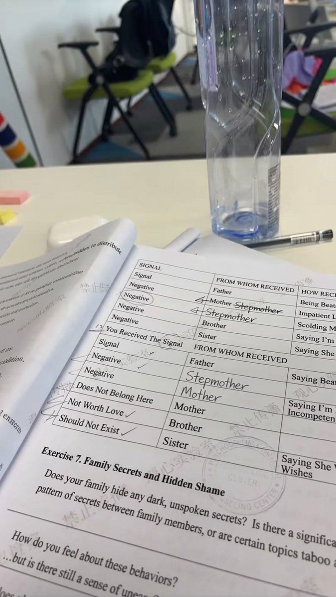 Printed course workbook open on a table during an in-person session, with handwritten exercise answers